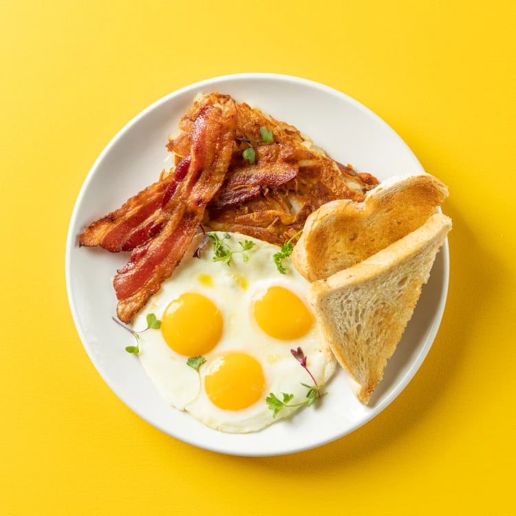 An image of the classic breakfast at poached, featuring eggs, bacon, hash browns, and toast.
